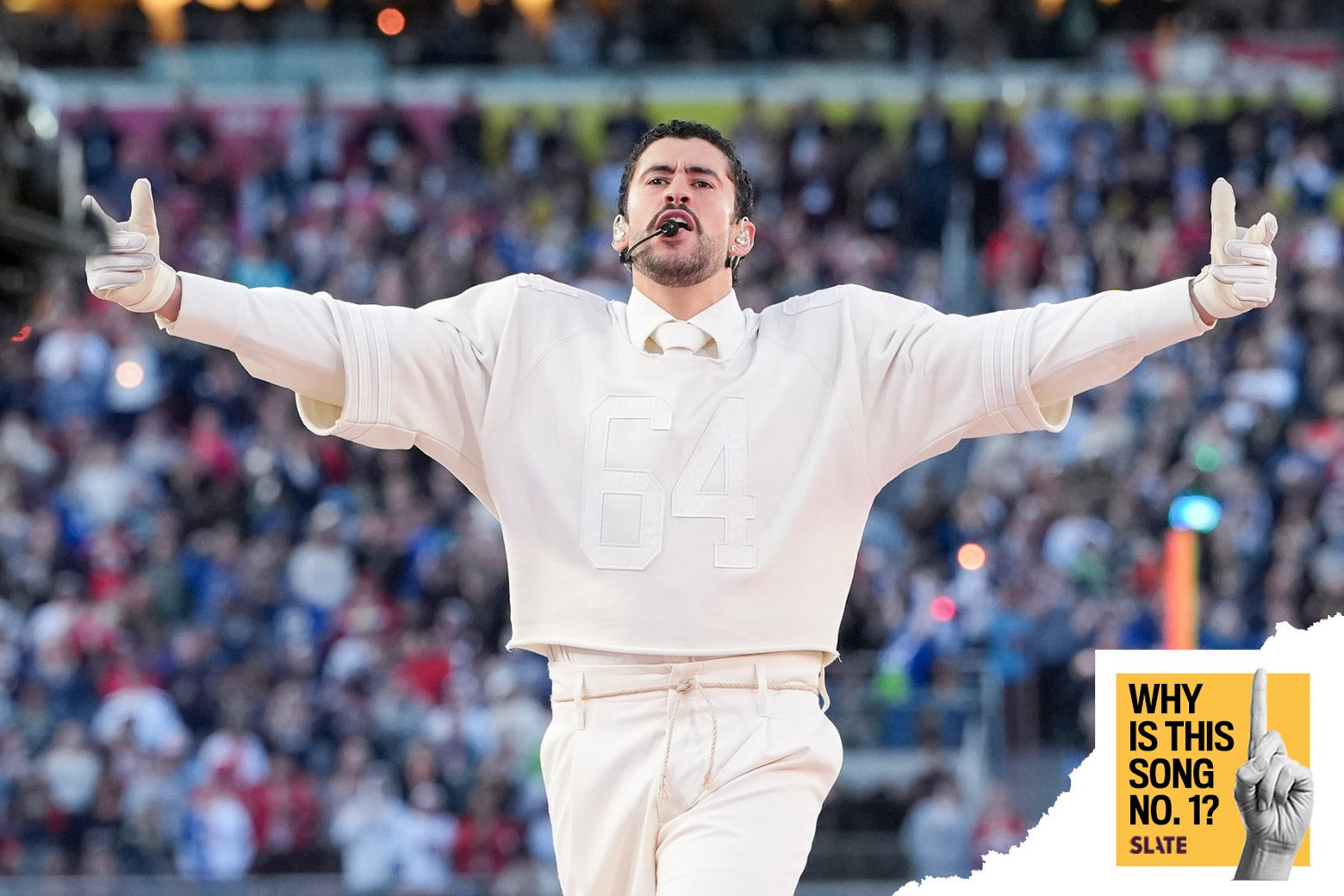 A photo shows Bad Bunny at the Super Bowl in front of a crowd of tens of thousands, in an all-white outfit including a football jersey with the number 64 on the front. He holds his hands up, and down to the right of him is photoshopped logos reading "Why Is This Song No. 1?" and below that "Slate."