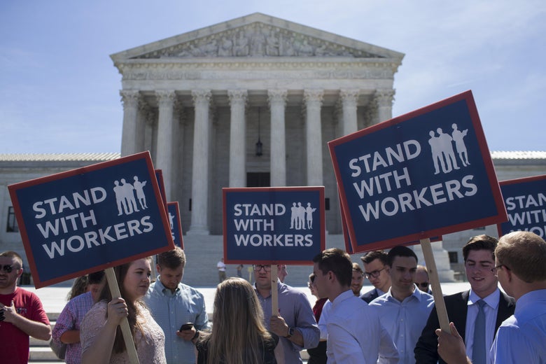 Demonstrators hold signs in front of the U.S. Supreme Court on June 25, 2018 in Washington, D.C. 