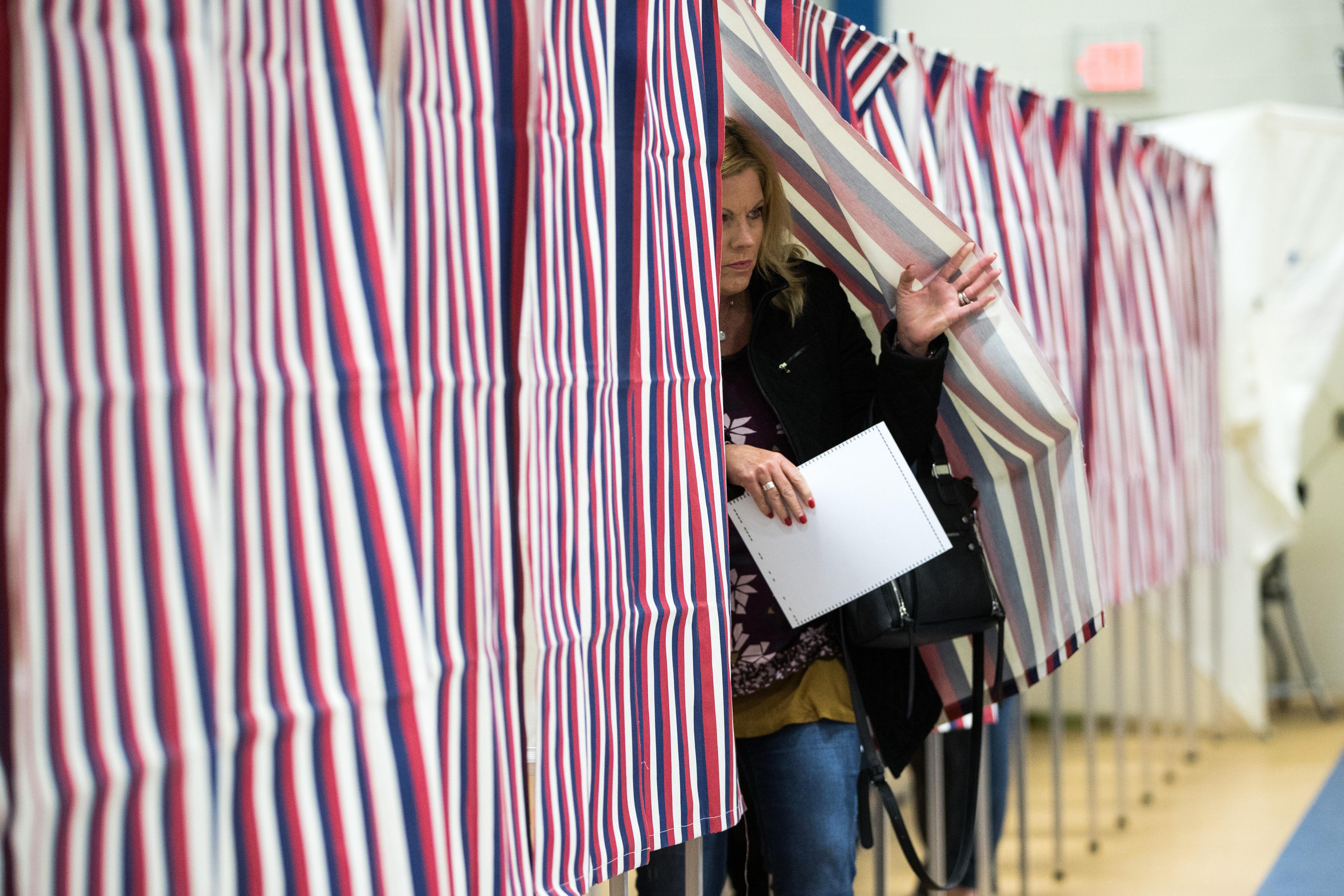 A woman exits a polling booth. 