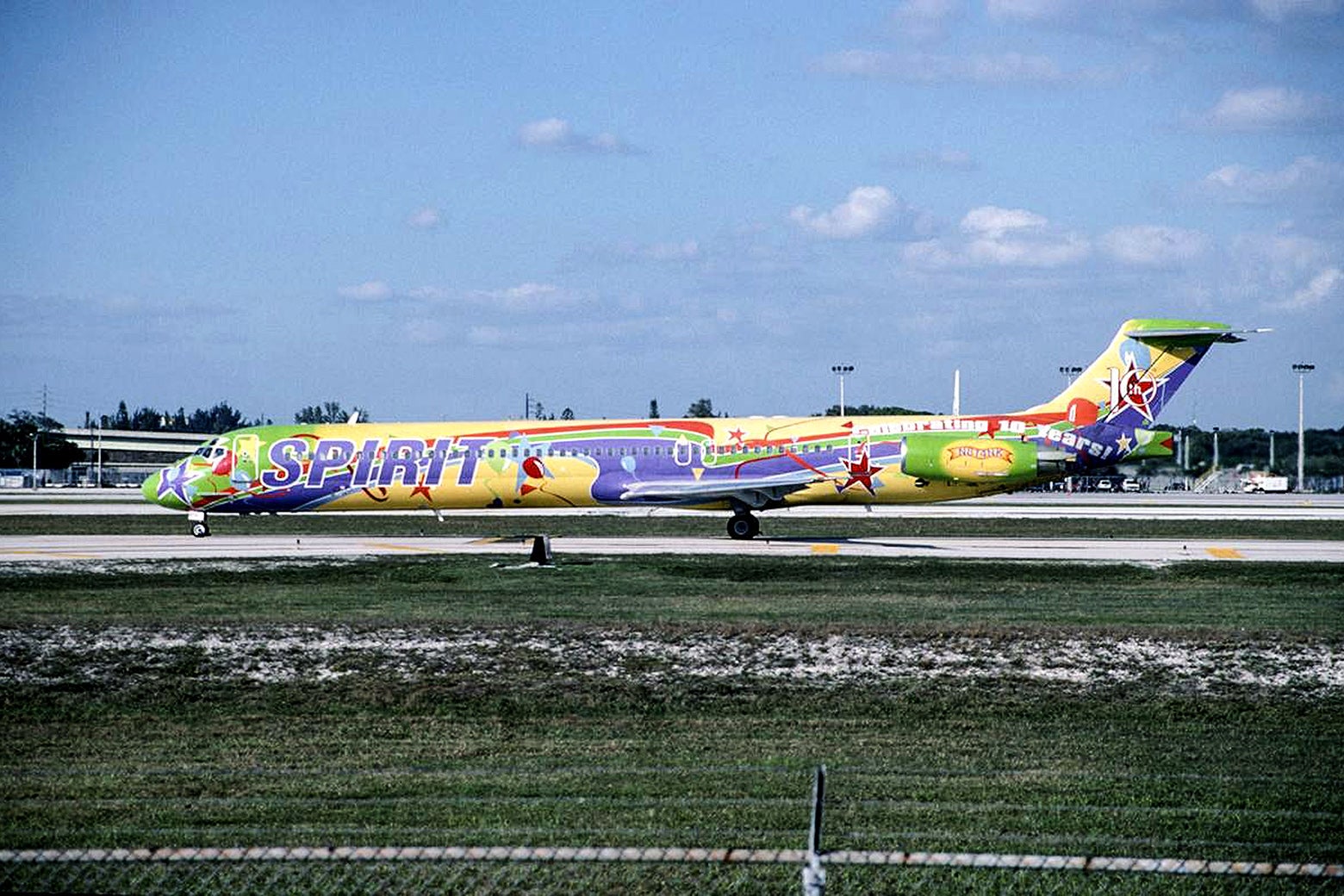 Multicolored plane at an airport.