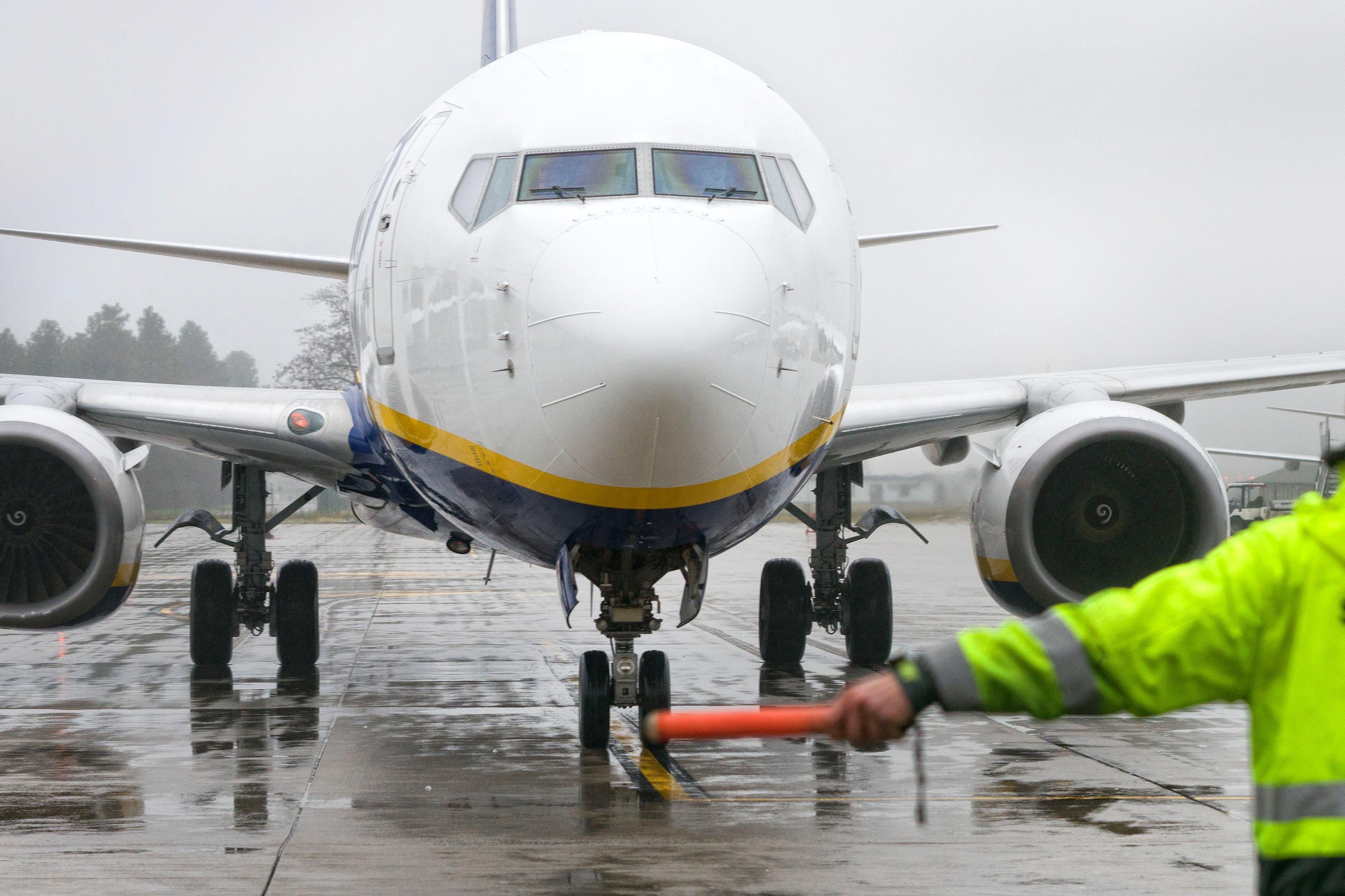 An employee helps a passenger aircrafts of the Irish low-cost airline company Ryanair to park on the tarmac of the airport in Weeze, western Germany on December 22, 2017.
Passengers travelling with Ryanair in Germany on December 22, saw little disruption from a four-hour strike called by a pilots' union, with most flights leaving as scheduled, and only some delays. Germany's powerful Cockpit union had asked Ryanair pilots to walk off the job from 5-9am (0400-0800 GMT) in a battle for recognition from the Irish no-frills carrier whose workers have been calling for better pay and conditions across Europe. But the first-ever strike action by Ryanair pilots in the company's 32-year history appeared to have made little impact, with no cancellations reported.

 / AFP PHOTO / dpa / Arnulf Stoffel / Germany OUT        (Photo credit should read ARNULF STOFFEL/AFP/Getty Images)