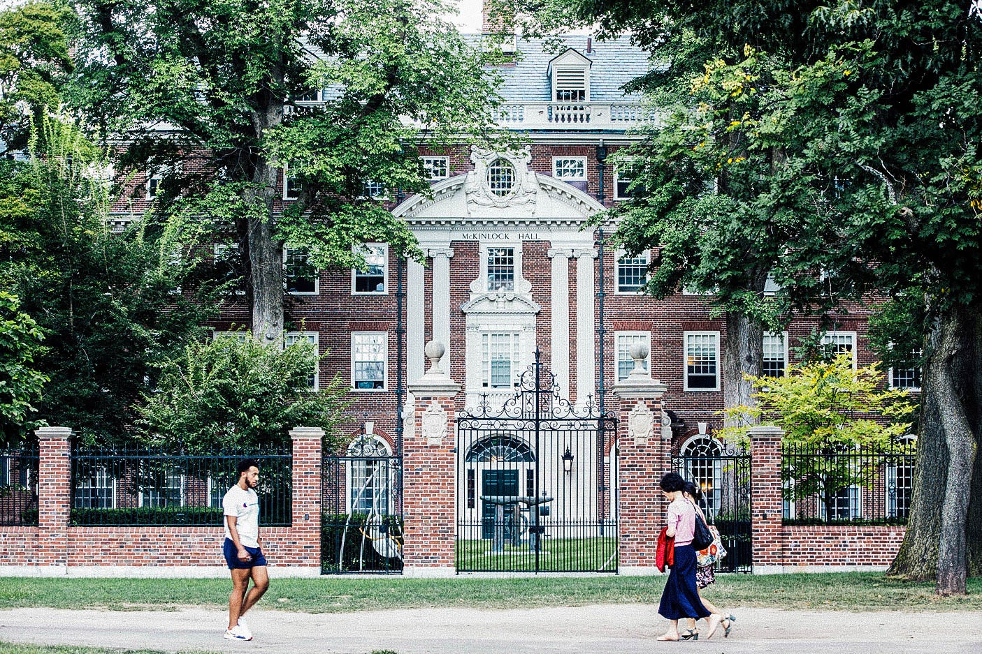 Pedestrians walk past a Harvard University building.