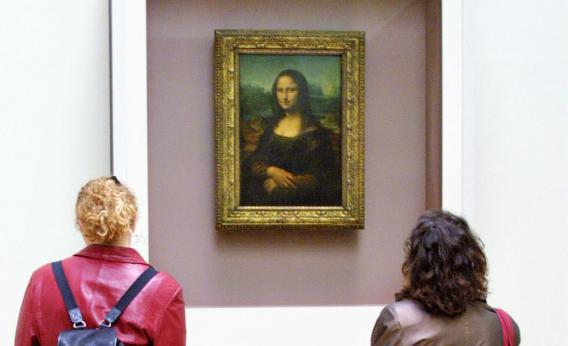 Visitors to the Louvre look at the Mona Lisa, which was stolen in 1911.