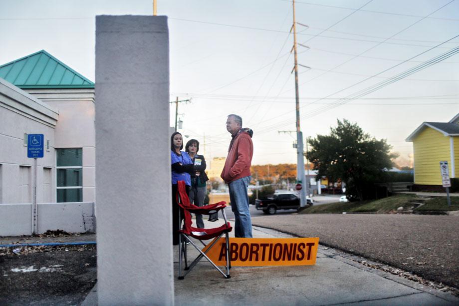 Pro-Life Mississippi president Dana Chisholm (center) and other protesters seen from the window of the security guard’s car as he drives one of the clinic’s doctors to the airport in November 2012. 