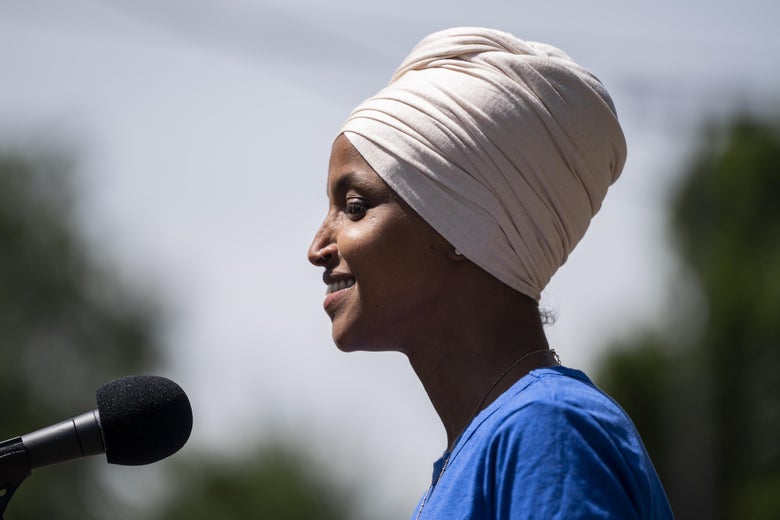 Ilhan Omar in profile, smiling as she speaks at a podium outside in Minneapolis on Aug. 11