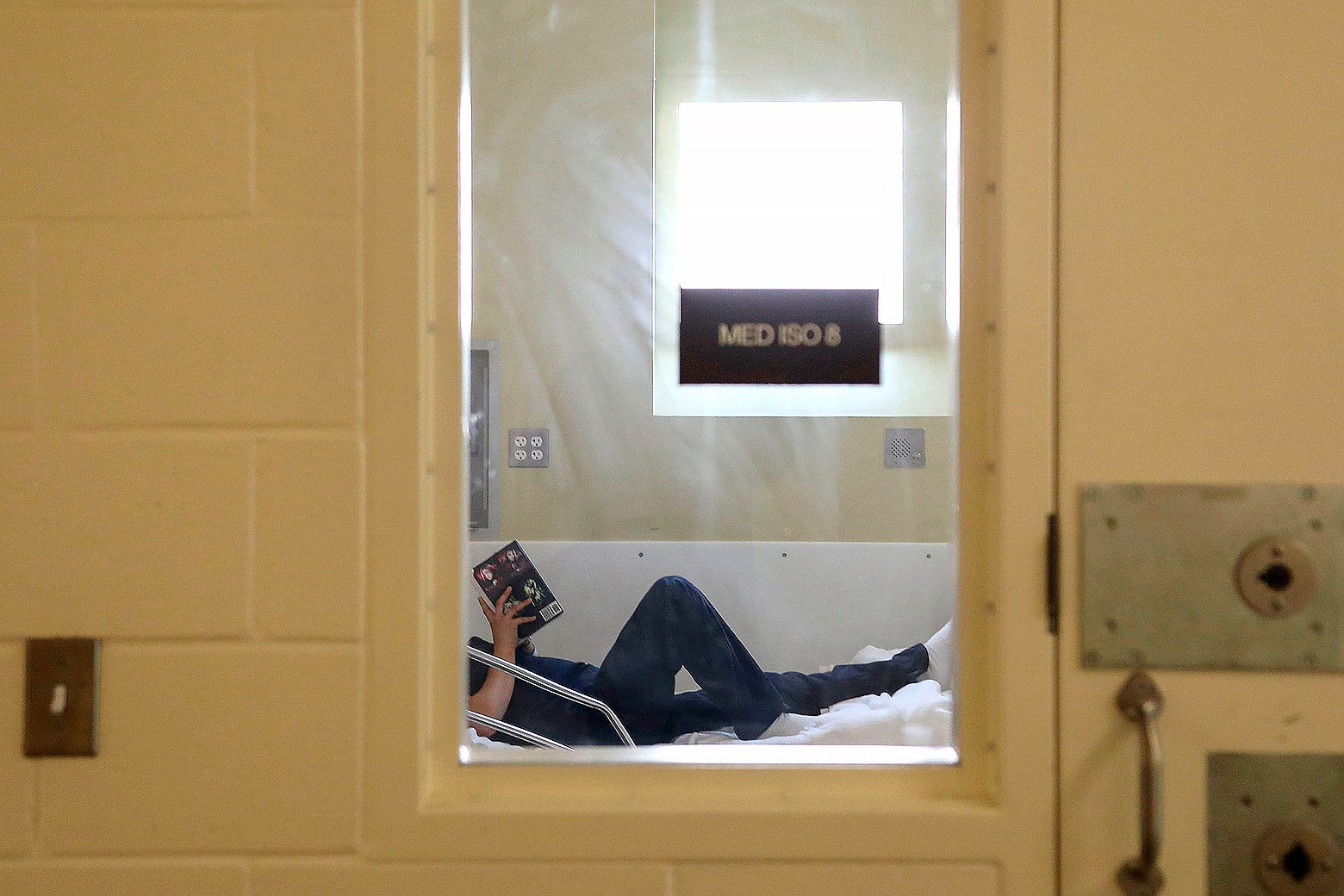 An inmate's legs through a window of quarantine.