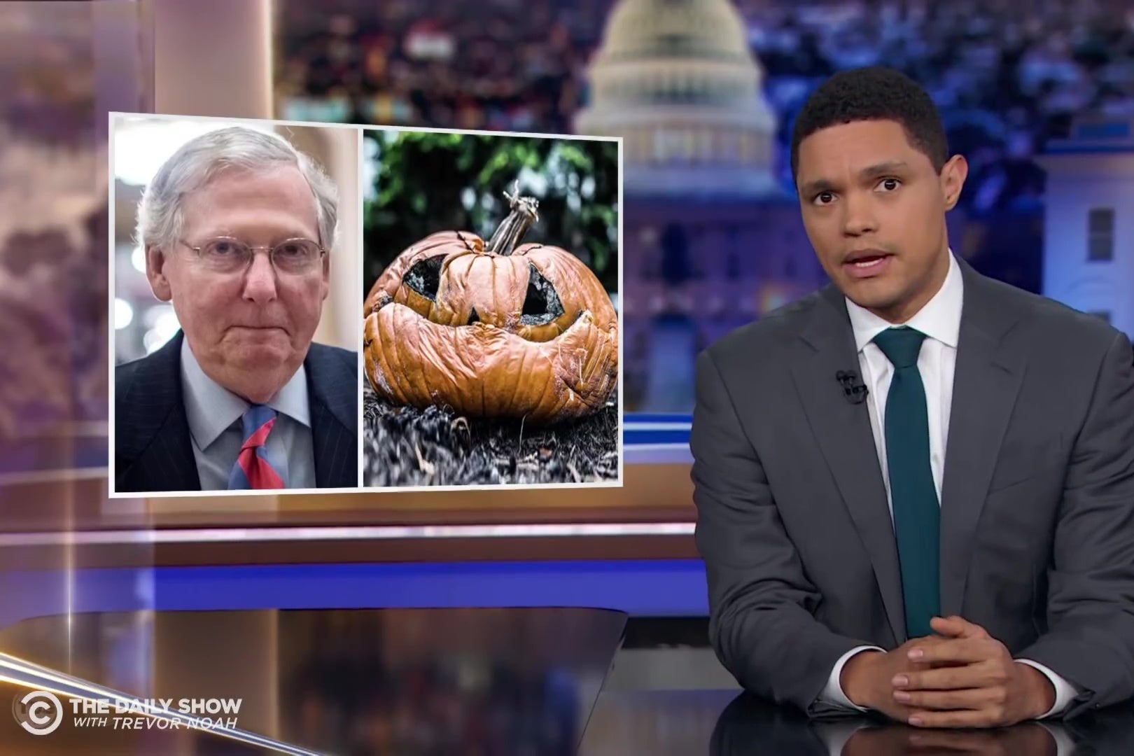 Trevor Noah of the Daily Show, in front of images of Mitch McConnell's face and a rotting jack-o-lantern that bears a strong resemblance to him.
