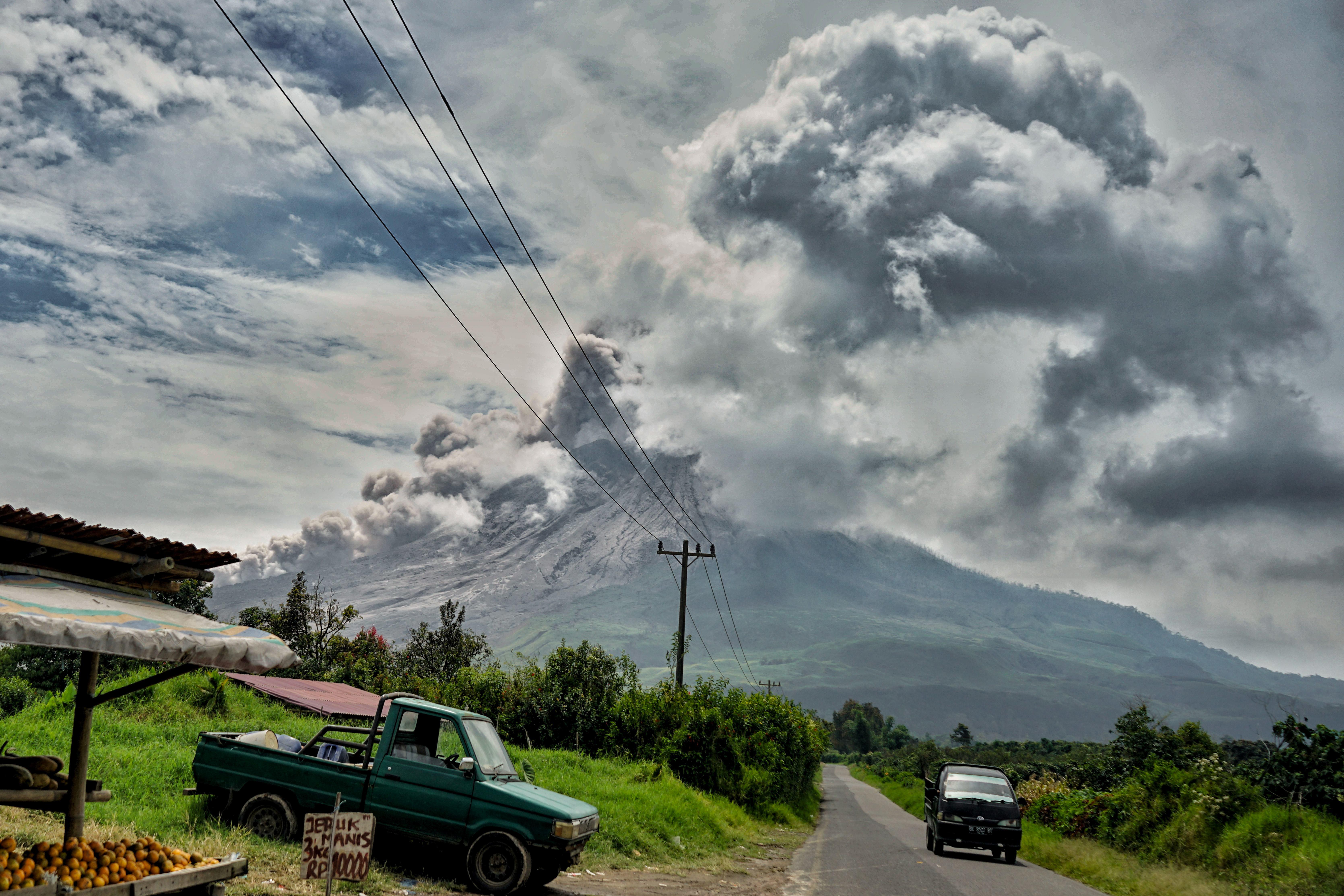 A volcano erupts and spews ash over a village 