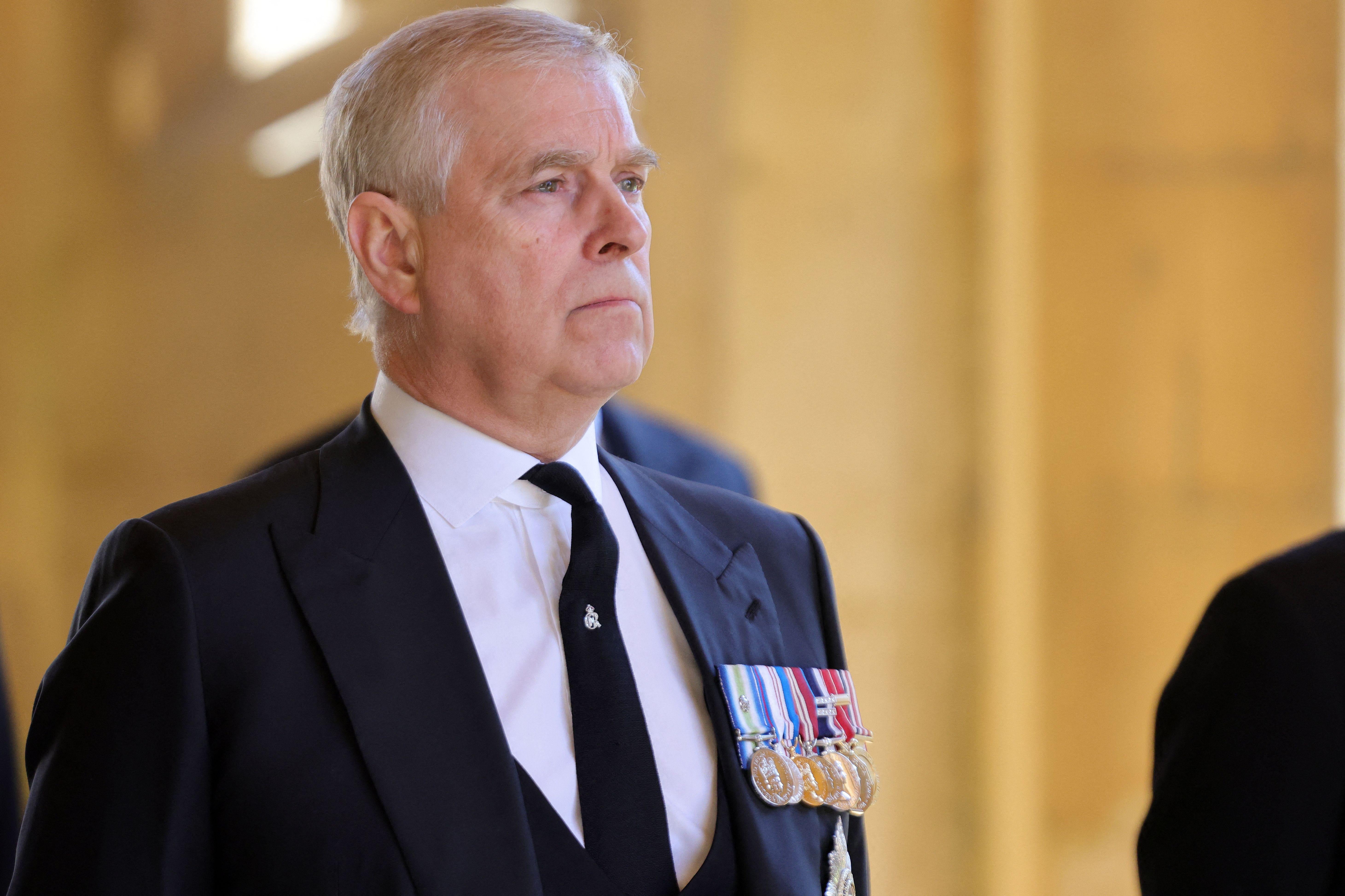 Prince Andrew in a black suit with medals pinned to the lapel.