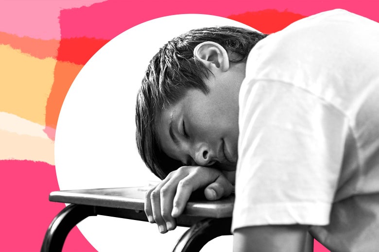 A kid sleeps on a desk.