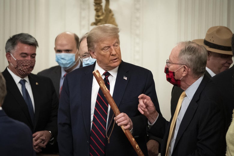 Sen. Lamar Alexander (R-TN) gives President Donald Trump a walking stick after the president signed the Great American Outdoors Act during a singing ceremony in the East Room of the White House on August 4, 2020 in Washington, D.C.