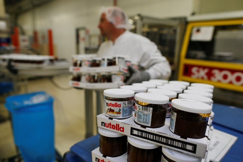 Man in factory carries Nutella pots.