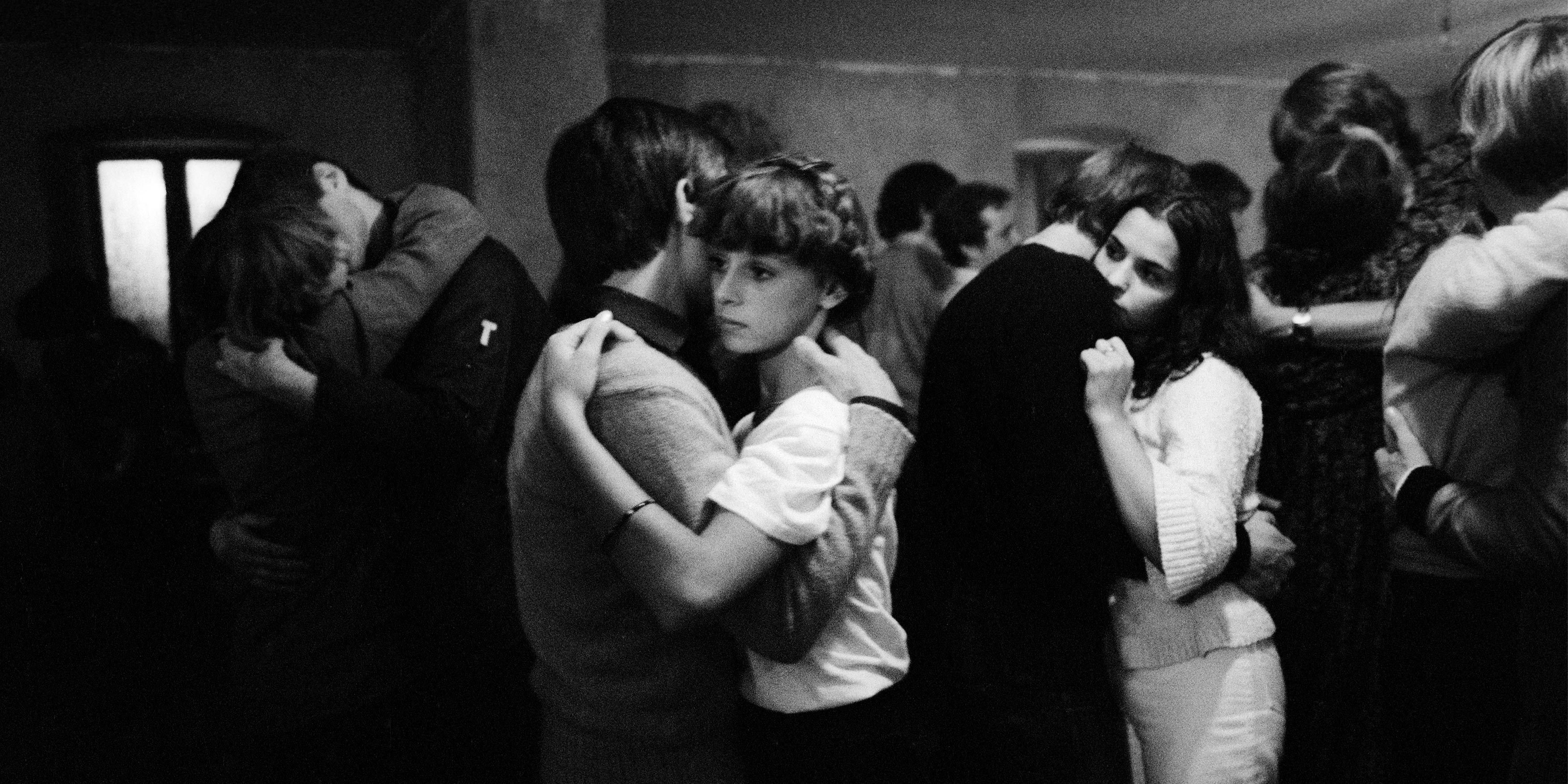 Partners dance while looking forlorn in a black-and-white photo.