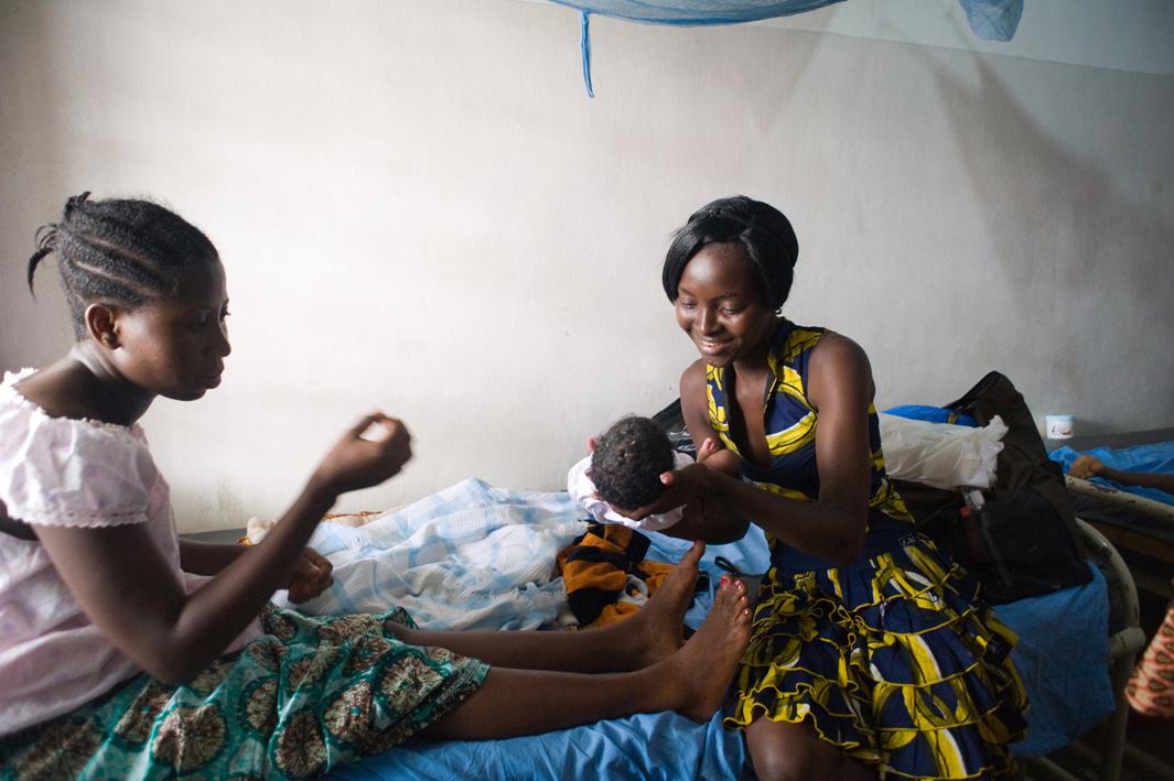 A visitor holds Habibat Adeboye's baby shortly after delivery at the Doctors Without Borders-run Aiyetoro Health Centre in Lagos, Nigeria. The clinic offers free care to women who live in a slum and have poor access to health care. At the time, federal doctors were on strike.