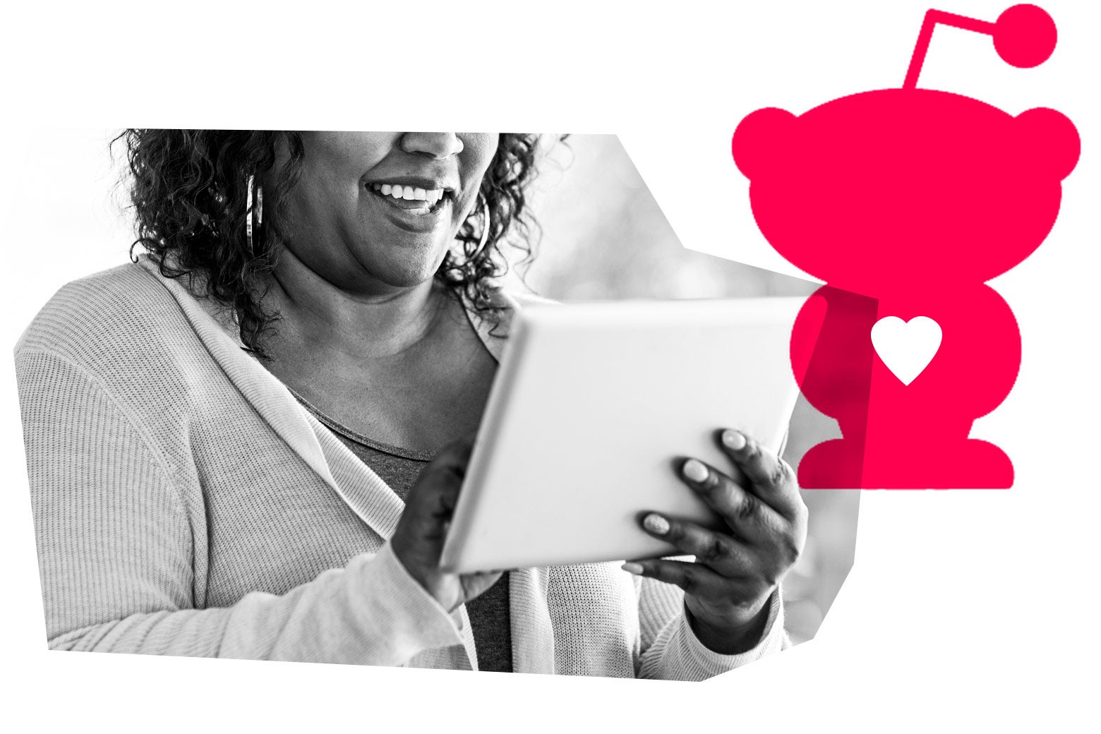 A Black woman smiles while looking at her tablet. A Reddit logo is in the background.