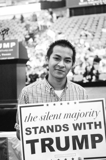 17-year-old Joseph Le poses with his sign before the rally, in D