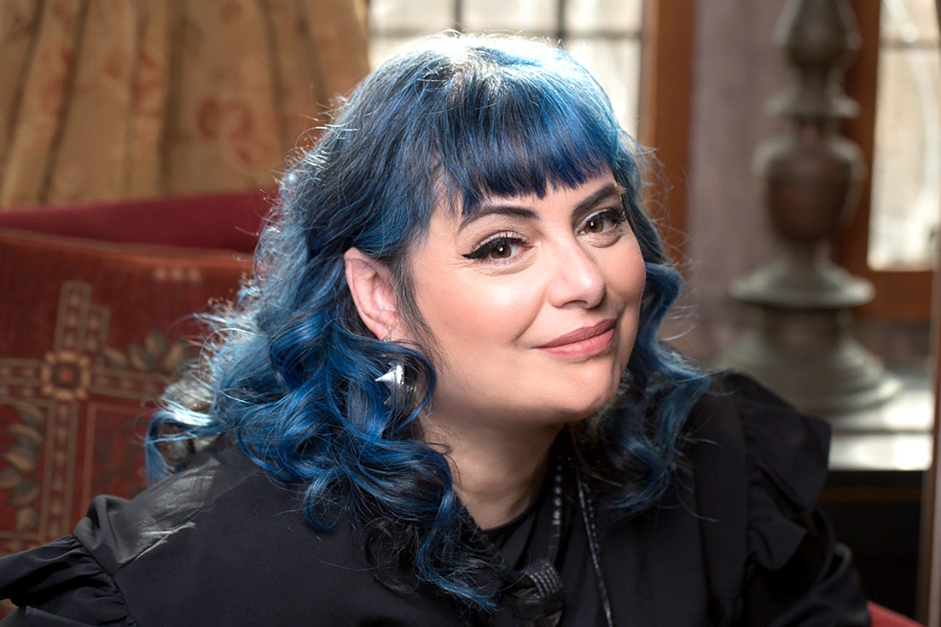 Holly Black, with blue hair and pointed ears, smiling at the camera.