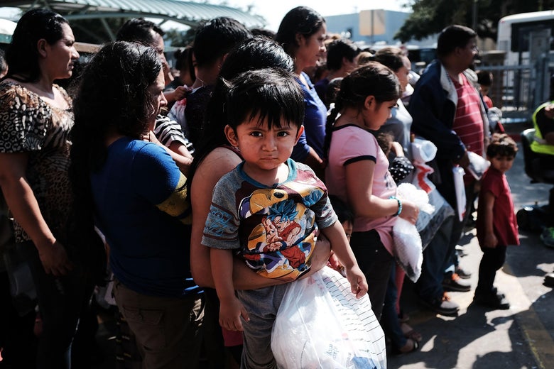 A small child at the center of a group of immigrants at the border in Texas.