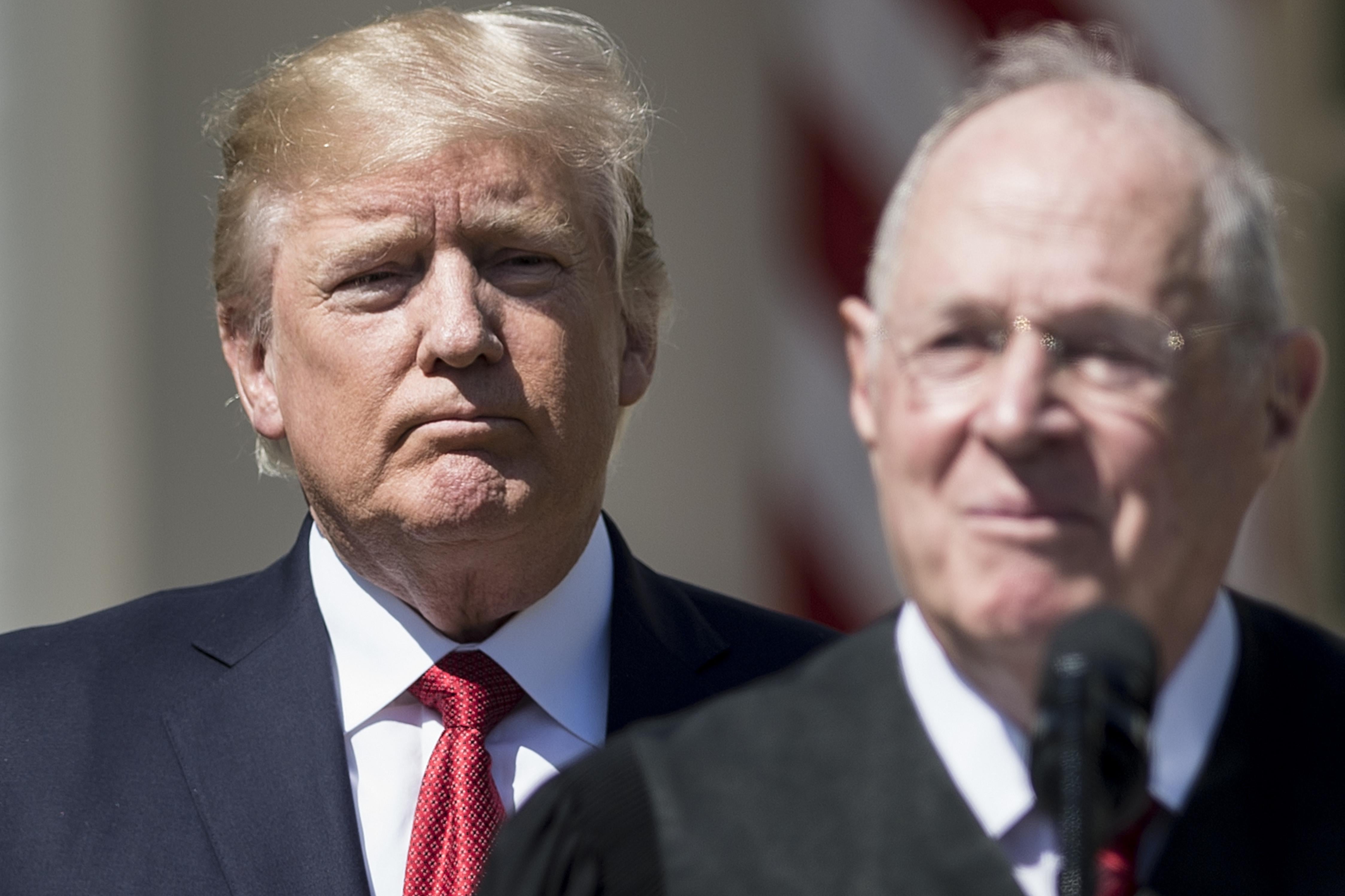 President Donald Trump listens while Supreme Court Justice Anthony Kennedy speaks during a ceremony on April 10, 2017, in Washington.