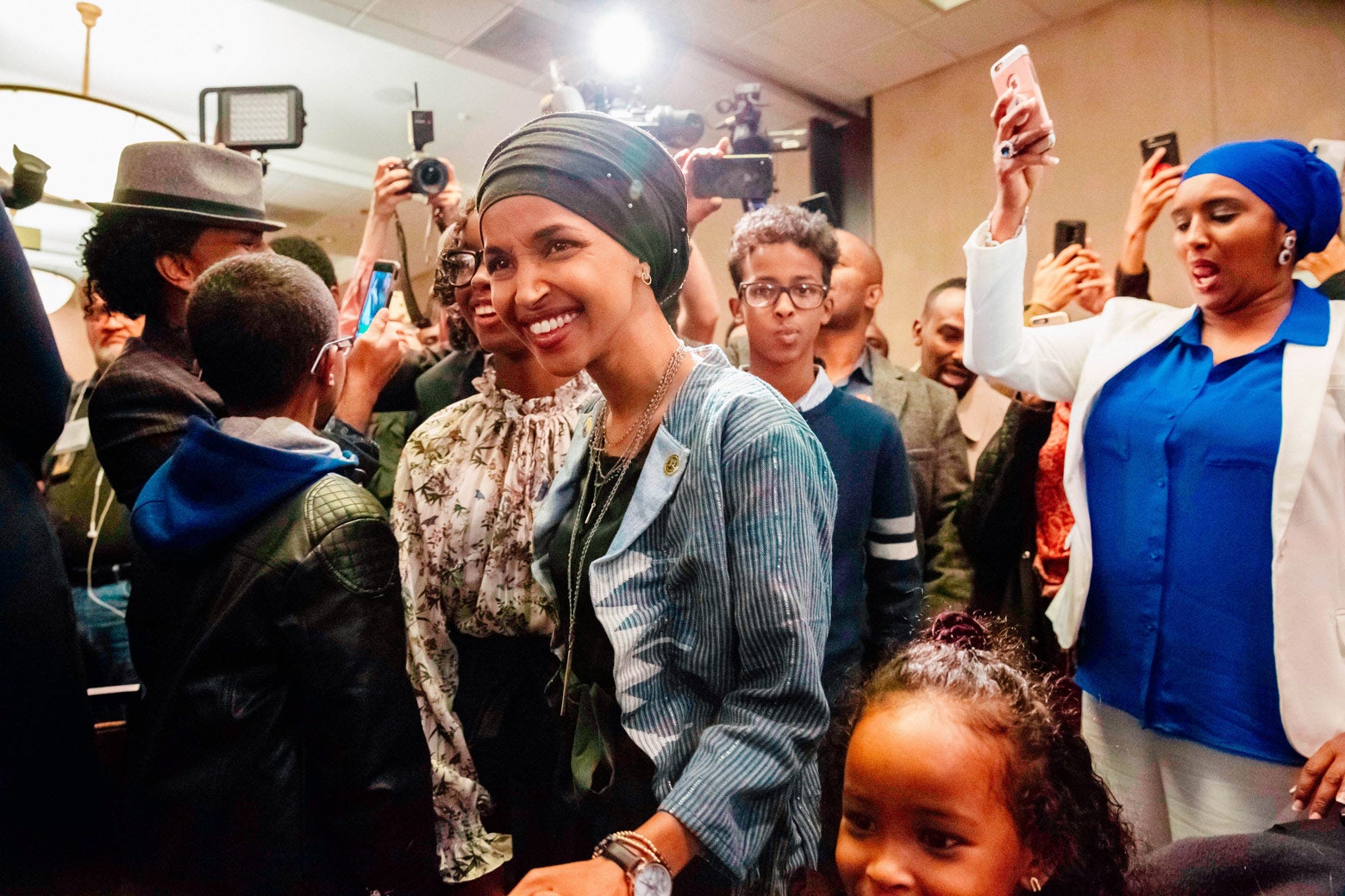 Ilhan Omar in a crowd of smiling supporters.