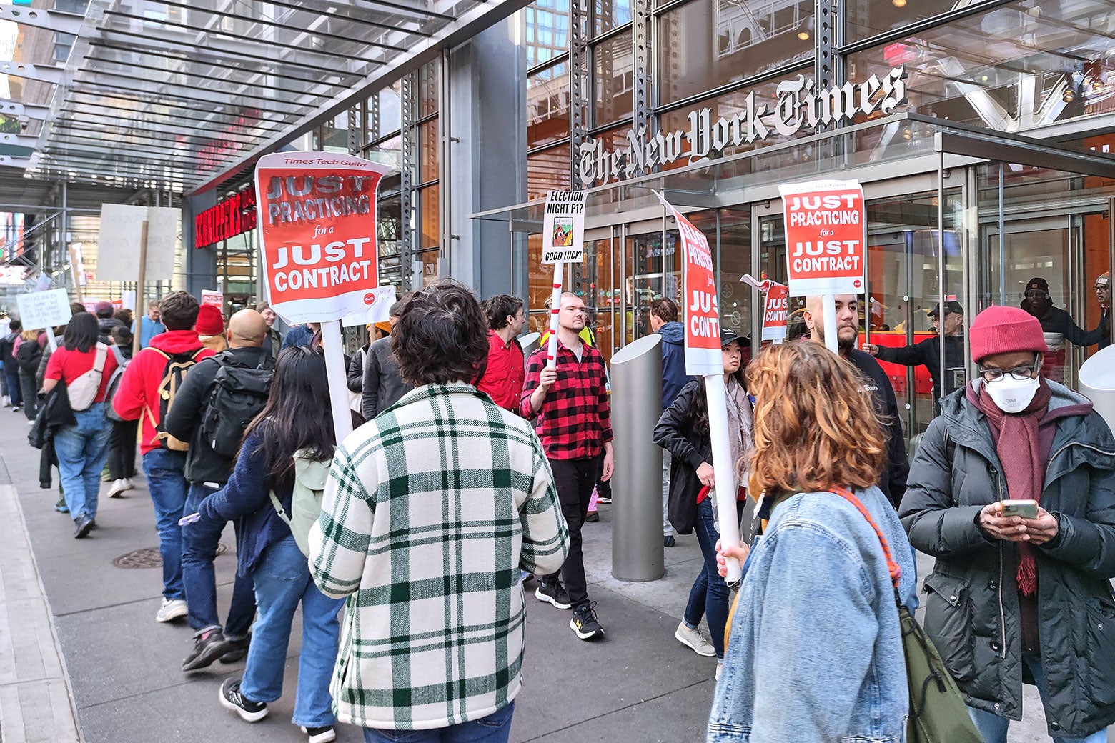 Members of the New York Times Tech Guild, many holding signs that read 