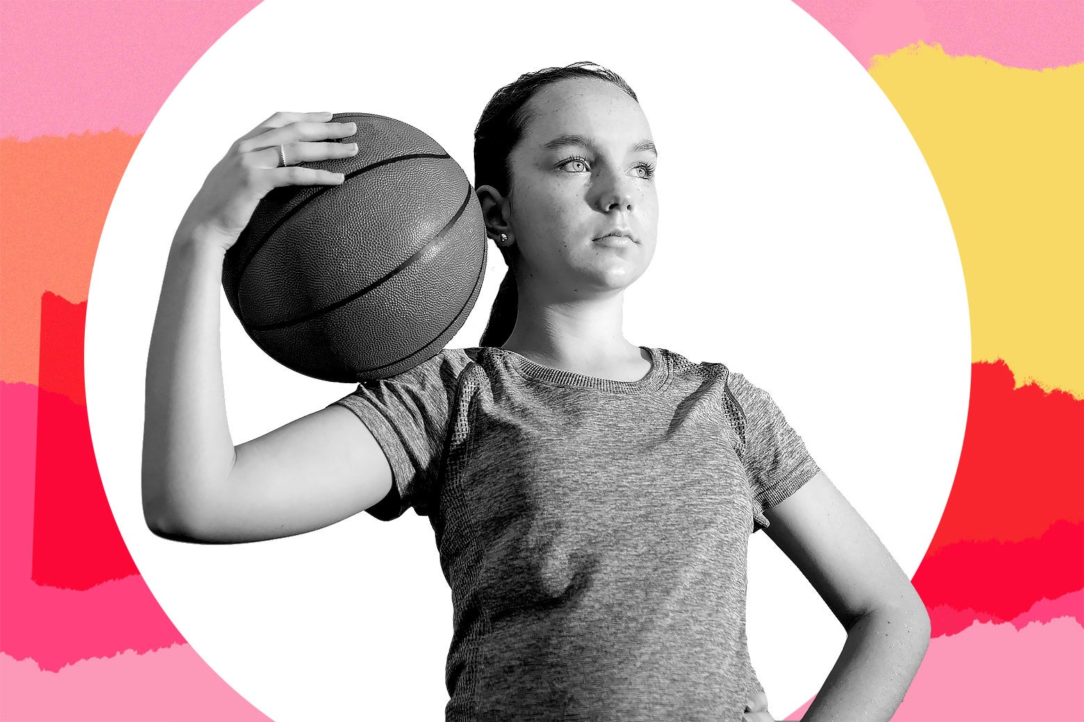 A girl holds a basketball on her shoulder.