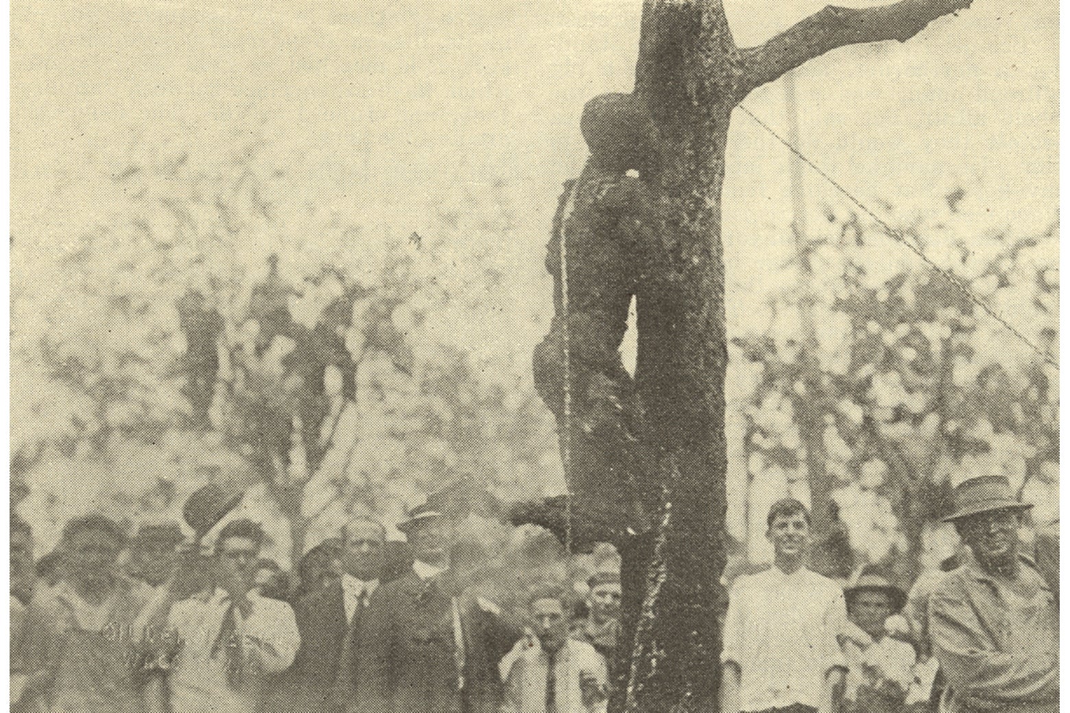 Smiling townspeople gather around the charred body of Jesse Washington.