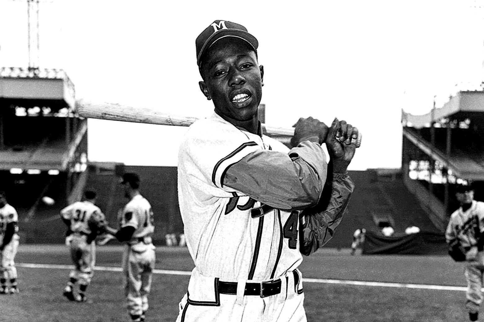 Aaron poses in his uniform, holding his bat over his left shoulder
