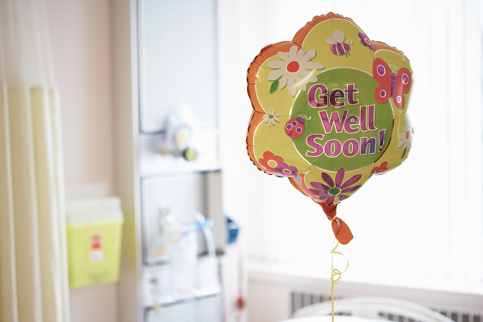 A "Get Well Soon" balloon in a hospital room.
