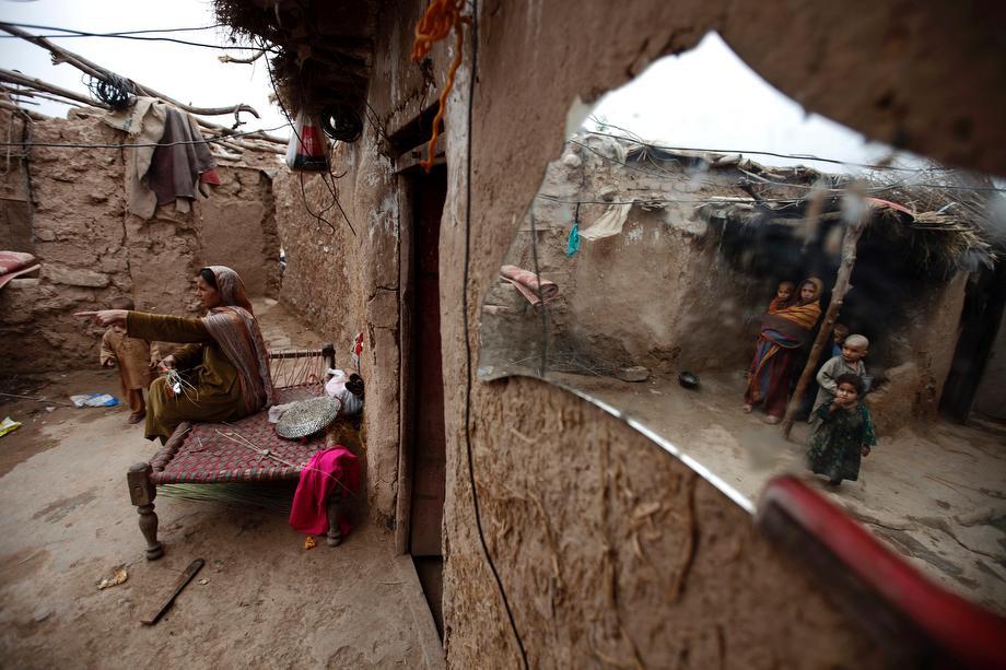 A woman talks to her children at her house in a slum on the outskirts of Islamabad, Pakistan on March 20, 2013.