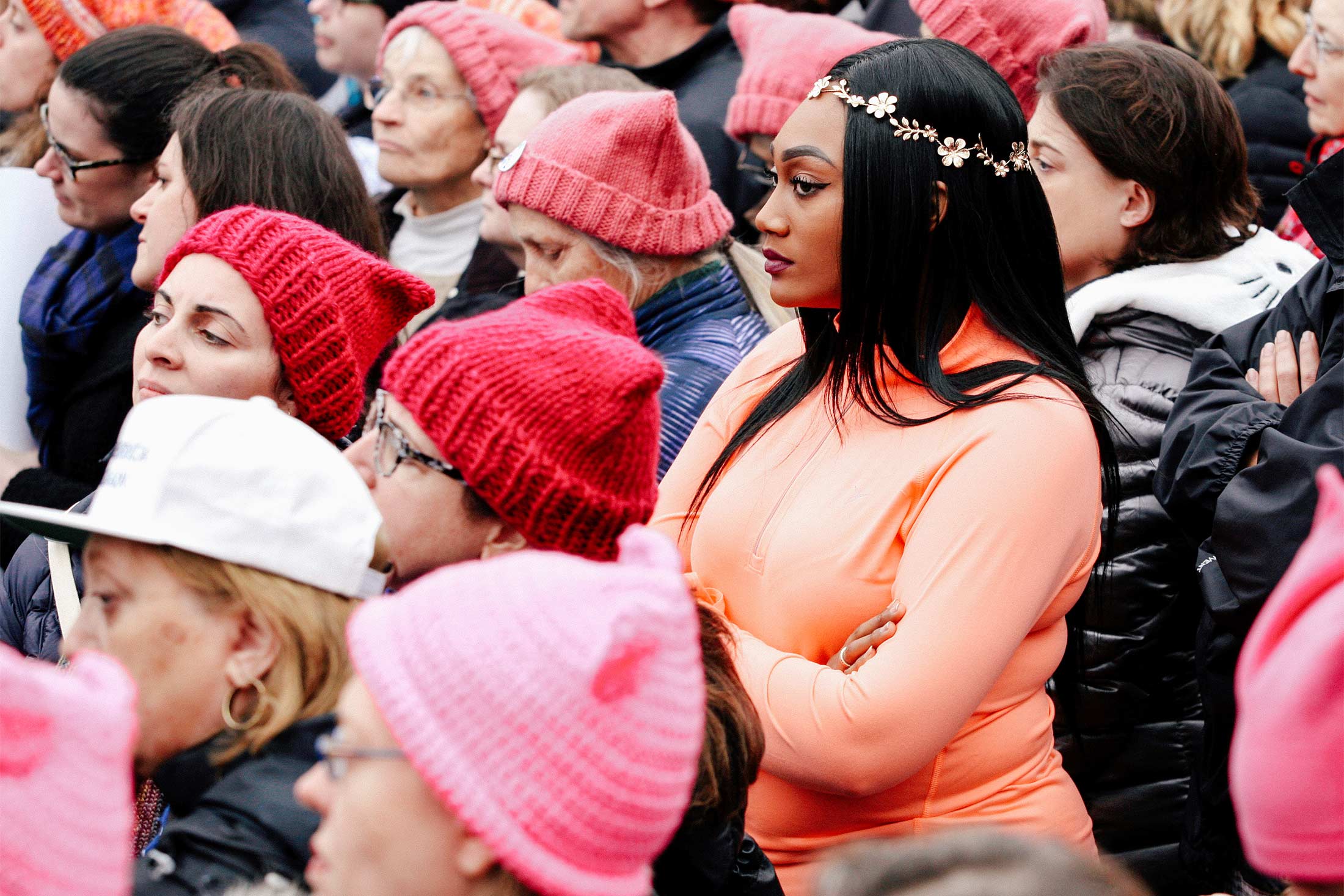 People wearing "pussy hats" and flower crowns listen to speeches at the 2017 Women's March in Washington.