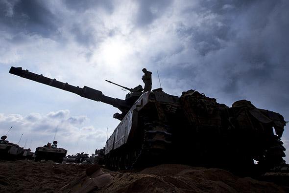 An Israeli soldier prepares a Merkava tank at an army deployment along the border between Israel and the Hamas-controlled Palestinian.
