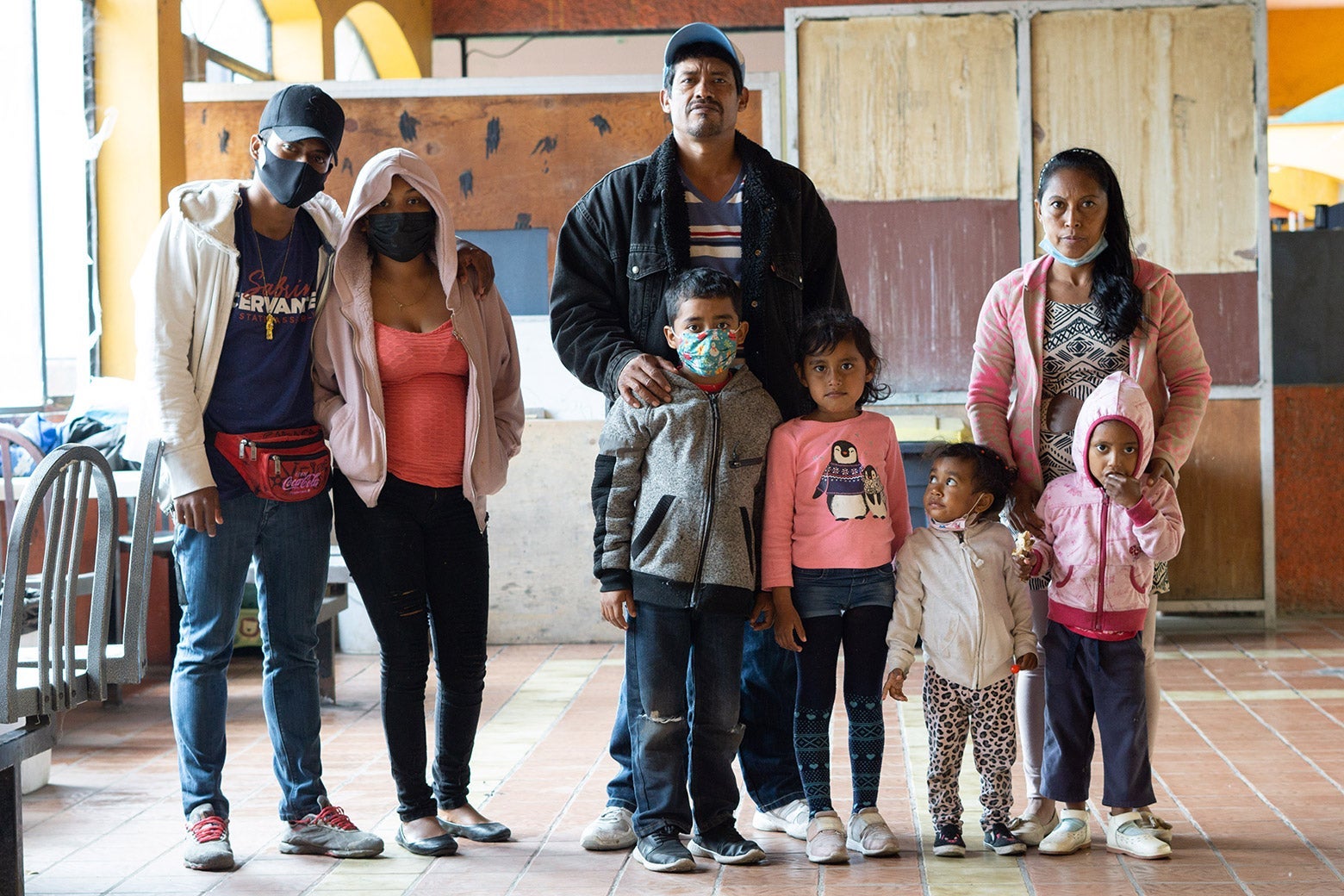 A man and woman stand with four smaller children and two older children off to the side.