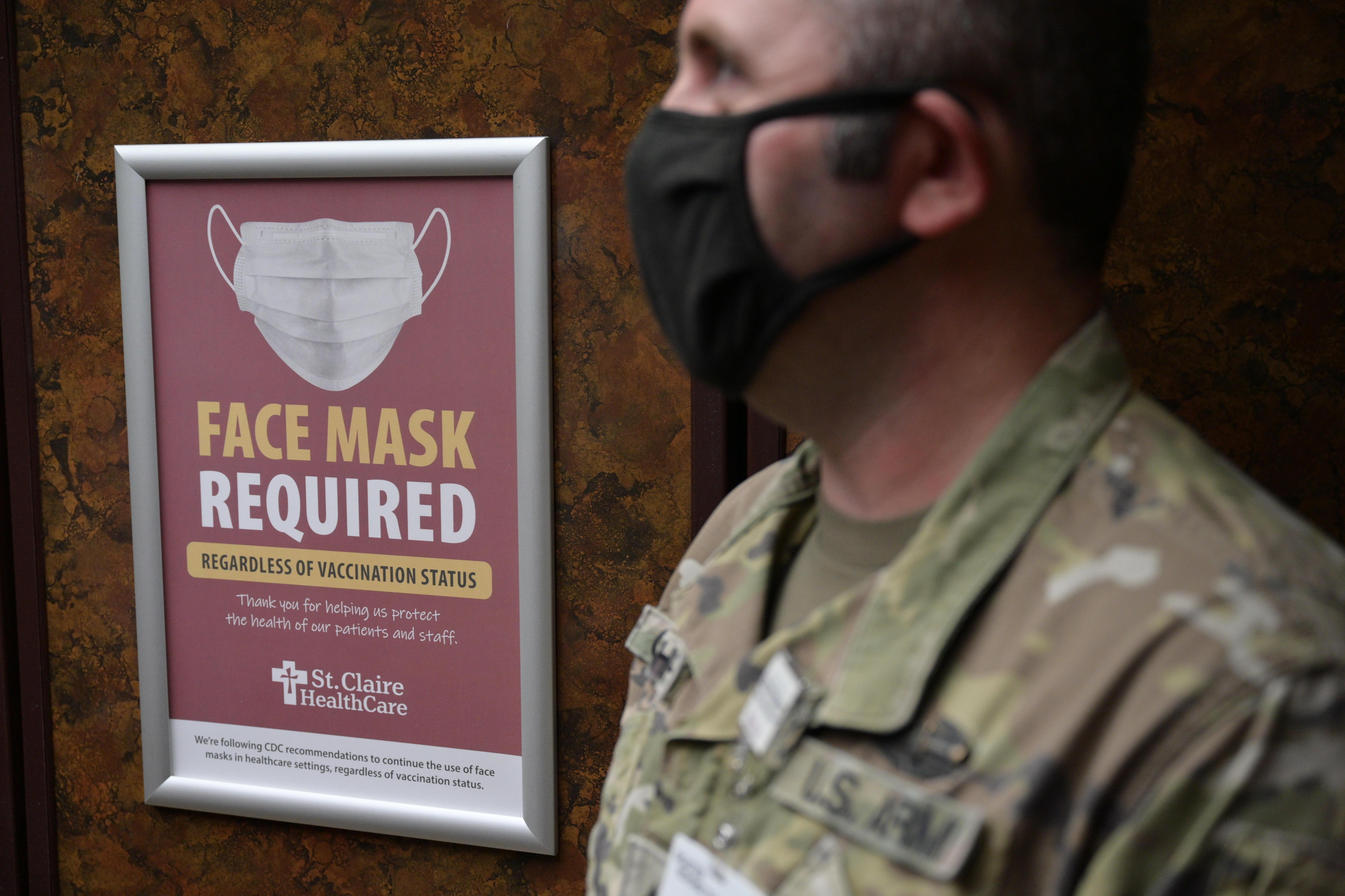 Sgt. Darrin Cushard of the Kentucky National Guard stands near a sign in an elevator denoting mask use in St. Claire Regional Medical Center on September 16, 2021 in Morehead, Kentucky.