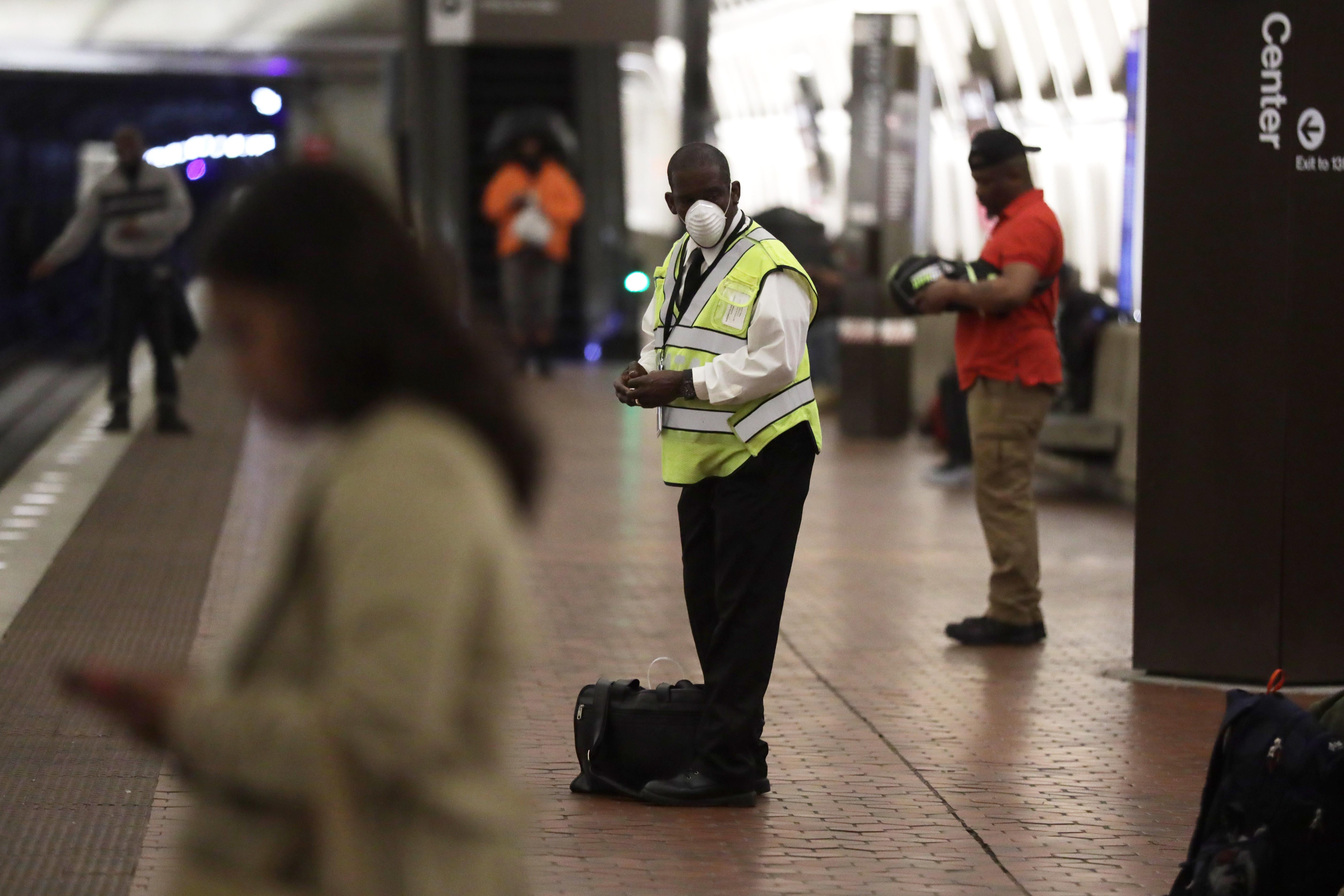 A man wears a mask as he waits for his train at Metro Center Metro Station. 
