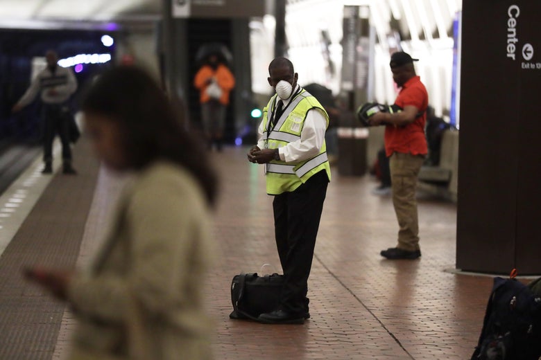 A man wears a mask as he waits for his train at Metro Center Metro Station.