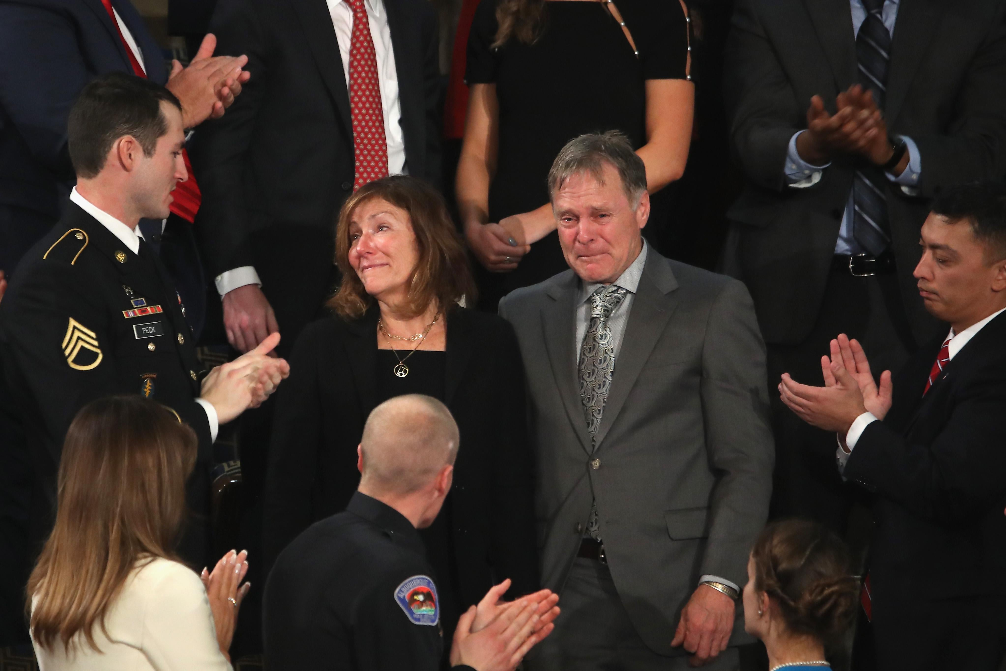 Fred and Cindy Warmbier, both weeping, stand as the surrounding crowd at the State of the Union address applauds.