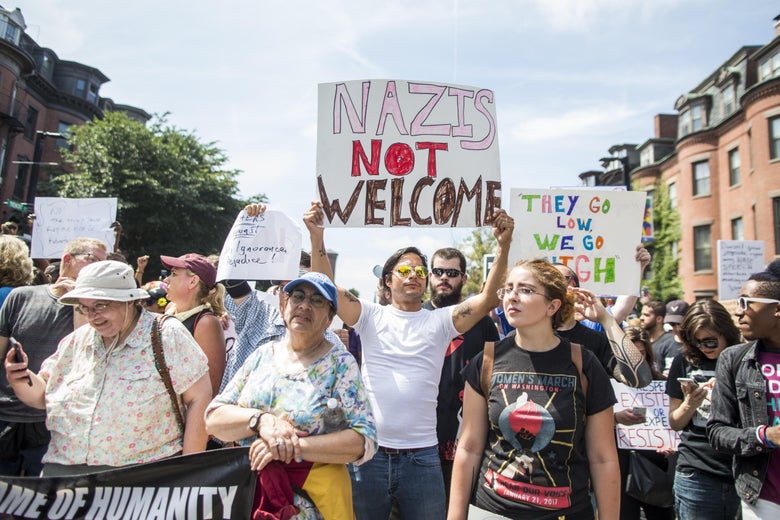 Counterprotesters holding anti-Nazi signs.