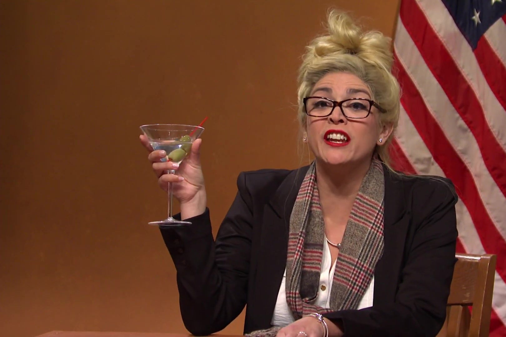 Cecily Strong, dressed as Melissa Carone, holding a martini, in a still from SNL.