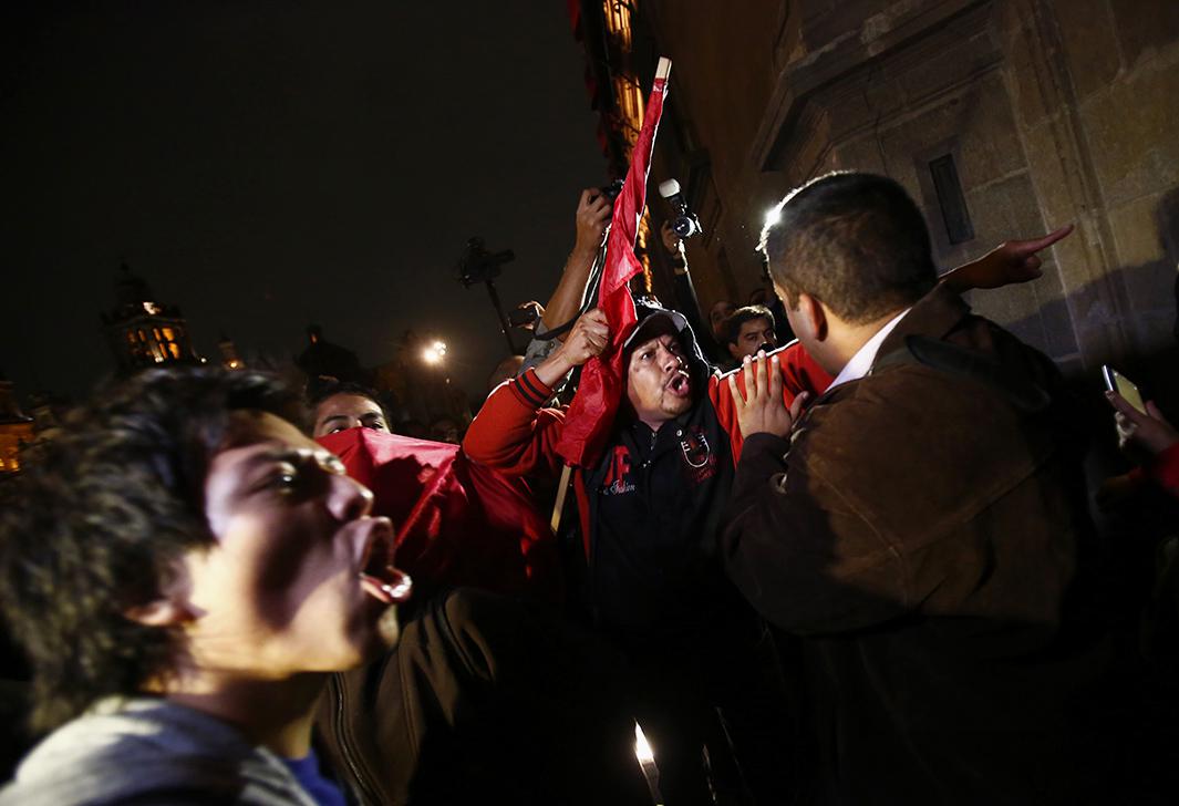 Protesters argue with a member of security outside the palace on Nov. 8.