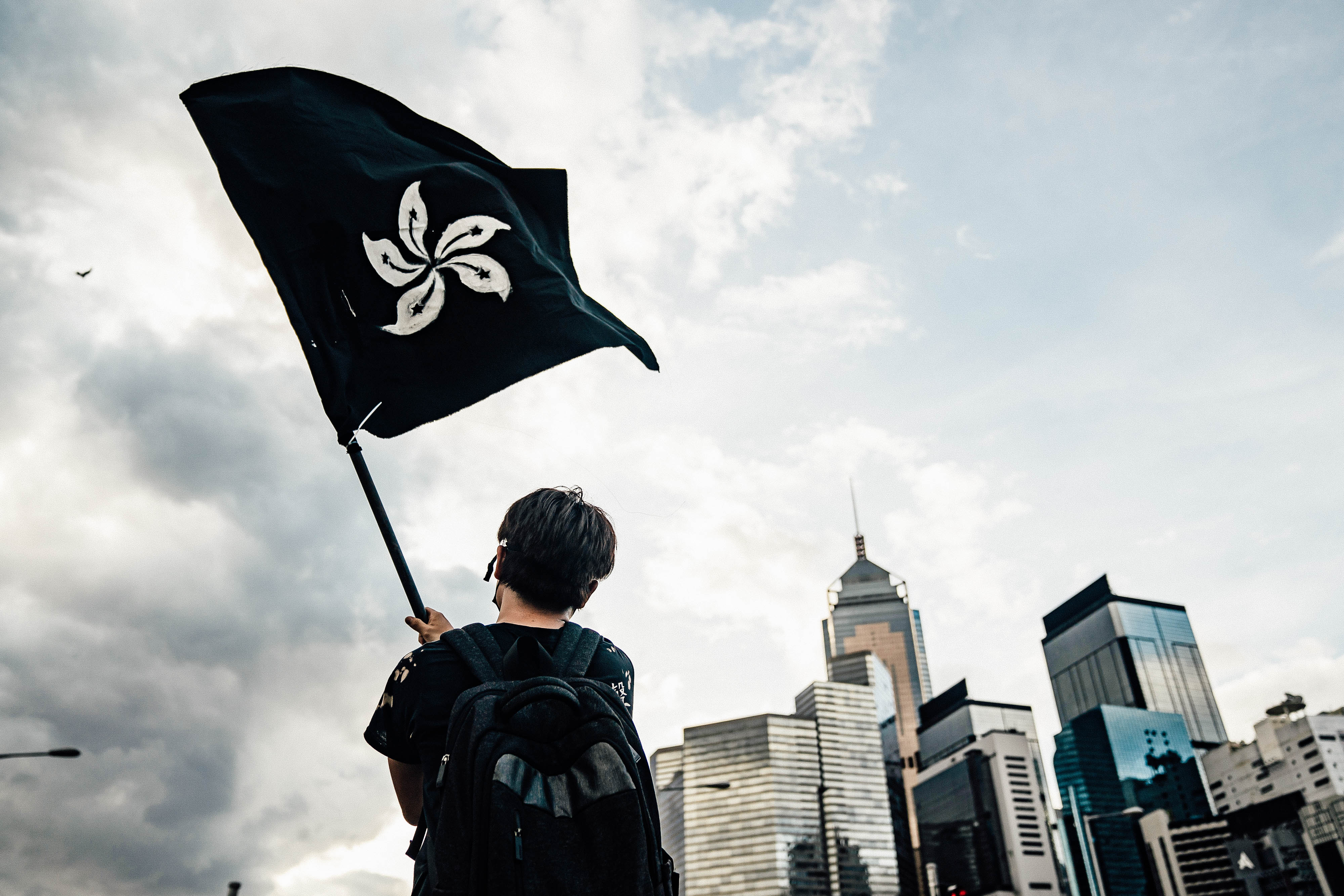 An anti-extradition protester waves a black flag on a street outside the Legislative Council Complex ahead of the annual flag raising ceremony of 22nd anniversary of the city's handover from Britain to China on July 1, 2019 in Hong Kong, China.