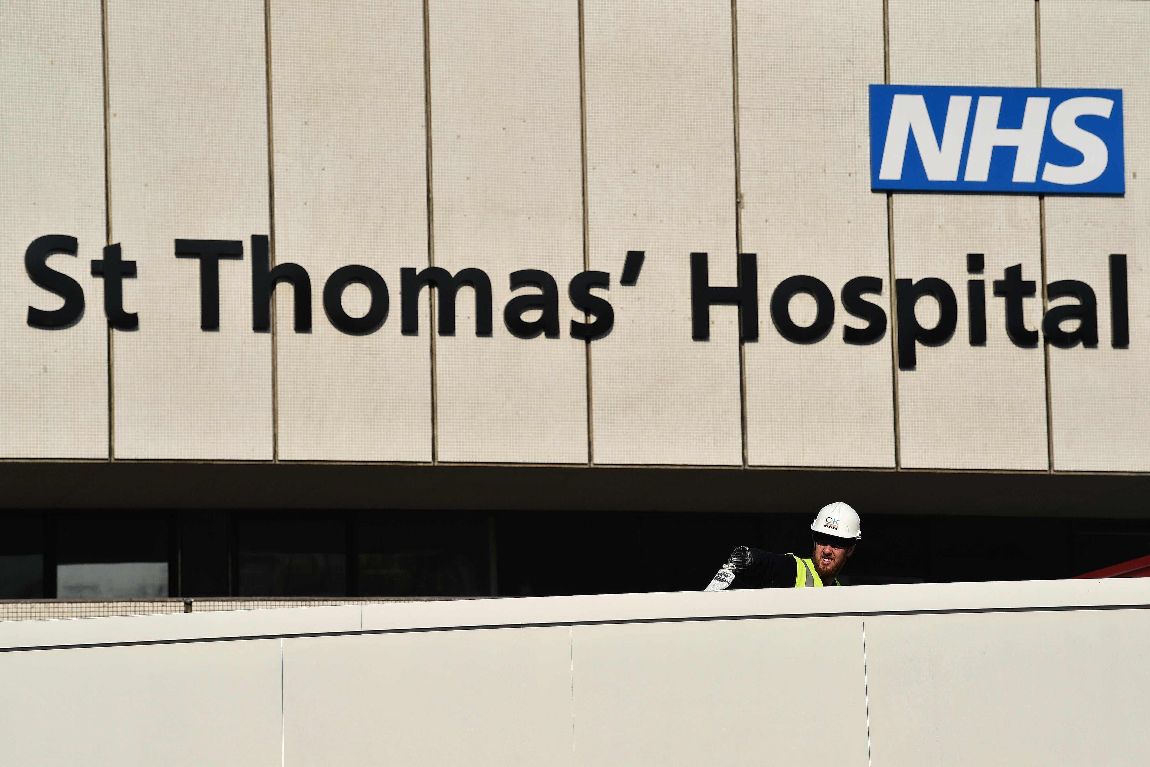 A worker paints a barrier outside St Thomas' Hospital.