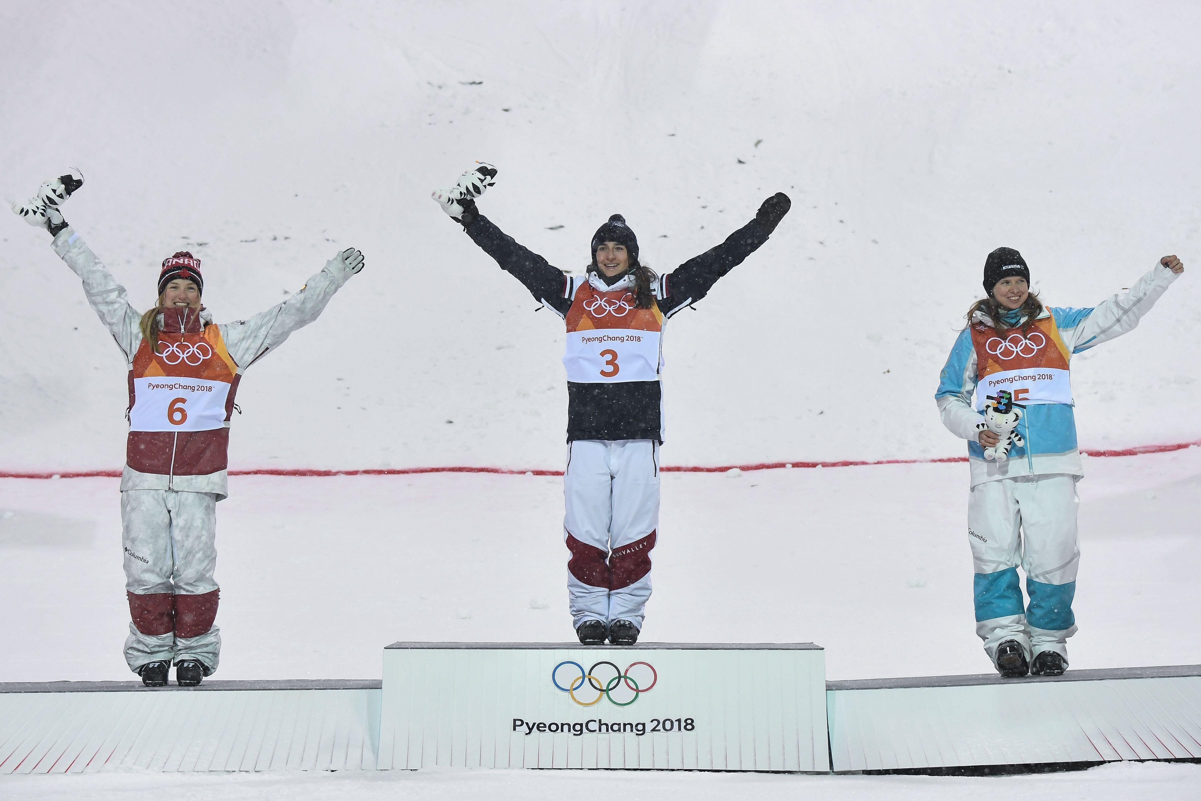 Canada's Justine Dufour-Lapointe, France's Perrine Laffont and Kazakhstan's Yulia Galysheva celebrate on the podium during the victory ceremony after the women's moguls final event.