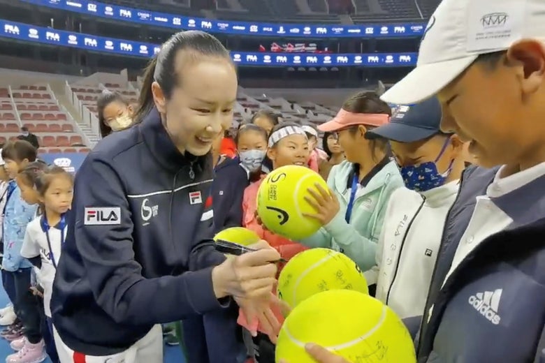 Chinese tennis player Peng Shuai signs large-sized tennis balls at the opening ceremony of Fila Kids Junior Tennis Challenger Final in Beijing, China November 21, 2021, in this screen grab obtained from a social media video. 