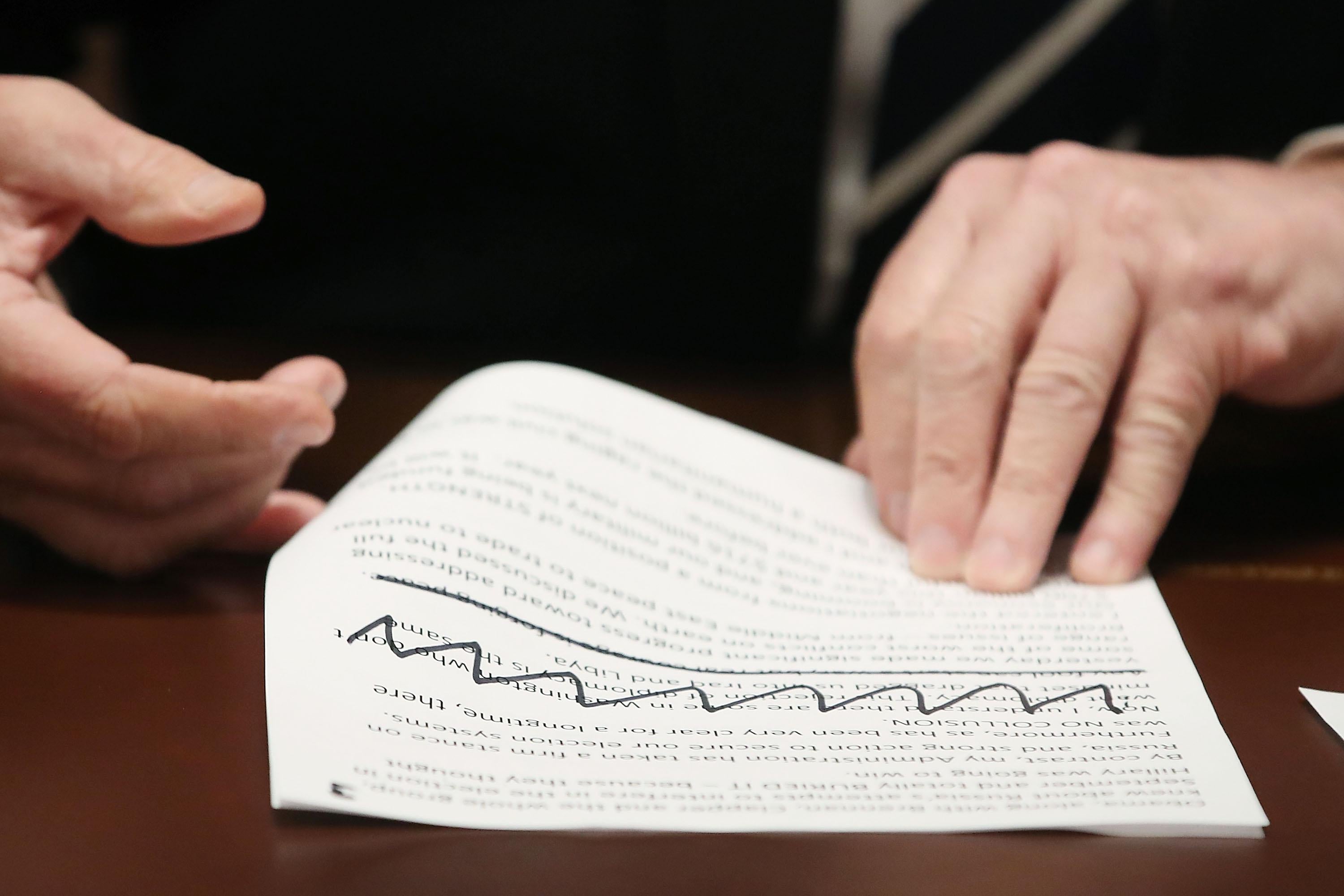 Trump’s hands hold typed notes with Sharpie'd scribbles on them.