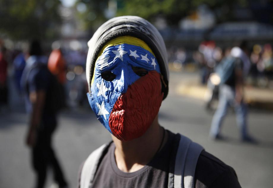 A demonstrator wearing a mask depicting the national flag takes part in a protest against President Nicolas Maduro's government in Caracas February 16, 2014. 