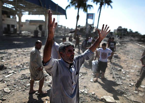 Palestinian man reacts inside the debris during the humanitarian truce in Khan Yunis, Gaza on August 1, 2014.