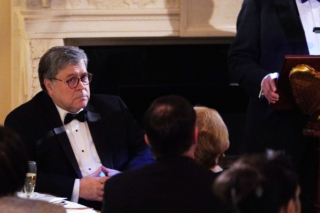 Barr is pictured seated at a table and wearing a tuxedo.