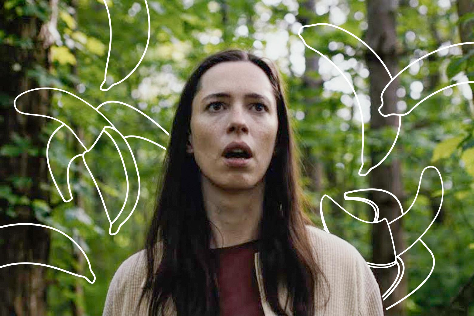 Rebecca Hall walks through a forest with a confused expression on her face, in a still from The Night House. Around her head, white outlines of bananas have been drawn onto the photograph.