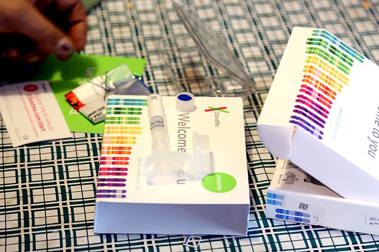 An opened 23andMe DNA test kit, including instructions and a container for a saliva sample.